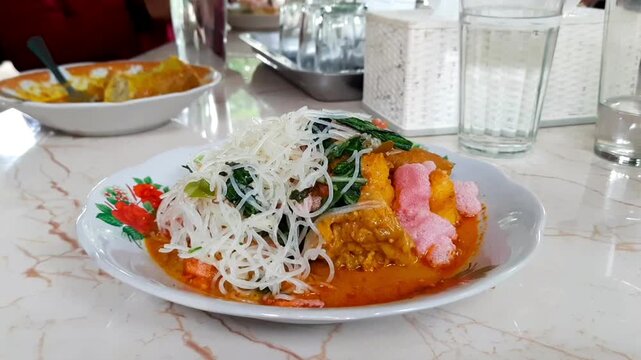 Traditional Minangkabau breakfast dish, Lontong Gulai Tunjang, served with coconut gravy, vermicelli, vegetables, and red crackers. Popular in West Sumatra, indonesian street food