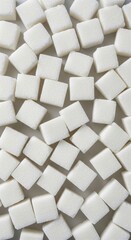 White sugar cubes on white background. Vertical template concept of sweet food, excess sugar, diabetes, proper nutrition and health care with copy space.