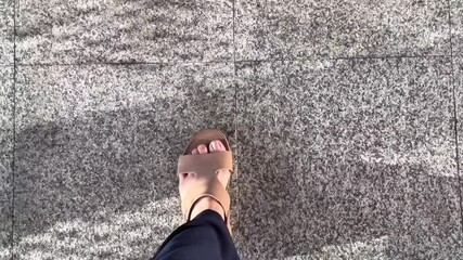 Close up pathway of people walking with smooth, tiled floor indoor in public area such as an airport terminal, shopping mall, or large station concourse.The movement is continuous travel flow.