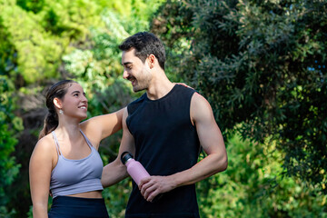 Couple smiling, showing support during an outdoor workout