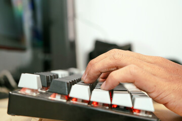 Close up of a male hands typing on a modern keyboard