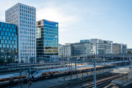Modern skyline and railway corridor through Oslo Barcode district, showing contemporary architecture and structured urban design under clear daylight.