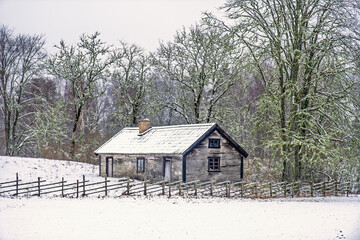 Idyllic old wooden croft with a fence at the forest edge a snowy winter landscape © Lars Johansson