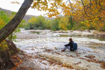  young girl with a backpack is hiking alone in nature