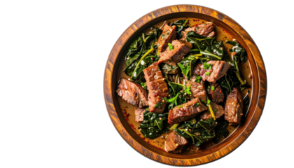 Sliced beef with greens served on a wooden plate