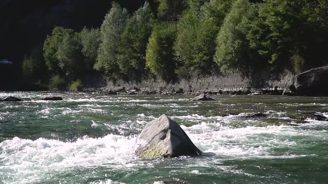 Wild mountain river running through stone rapids in carpathians in slow motion