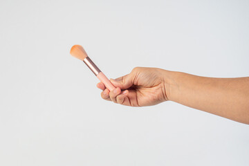 Pink cosmetic blush in hand on white background