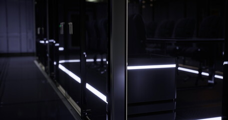 A contemporary conference room features minimalist decor, glowing LED lights along the perimeter, and stylish seating. The room is dimly lit, creating a sophisticated atmosphere for meetings.