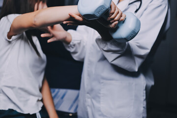 old woman training with physiotherapist using dumbbells at home therapist assisting senior woman with exercises in nursing home elderly patient using dumbbells with outstretched arms no logos no bran