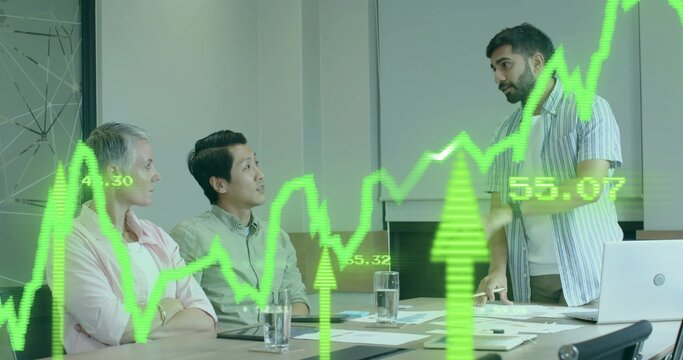 Standing Indian man presenting green stock chart at conference table with laptop papers copy space - Powered by Adobe