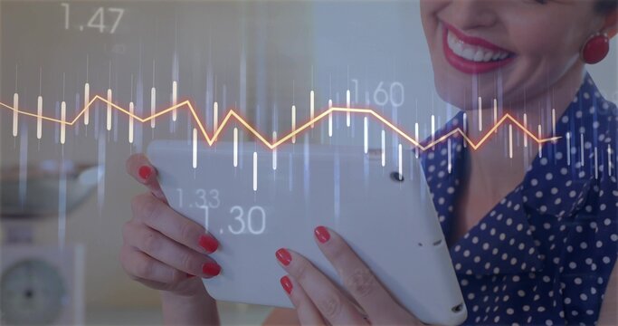 Examining woman wearing blue polka dot blouse holding tablet at desk, with financial chart overlay
