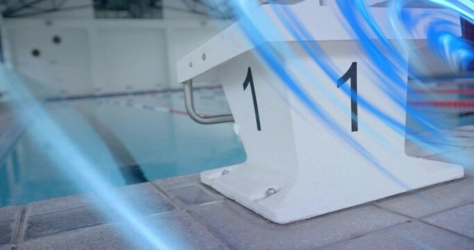 Highlighting white starting block labeled 1 on tiled deck shining under lights, ropes, blue streaks