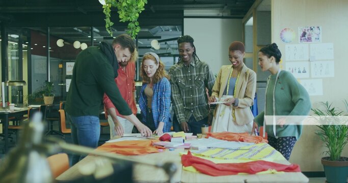 Collaborating design team sketching patterns at modern studio workshop, with fabric swatches