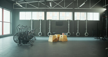 Interior, equipment and bicycle in empty gym for fitness, spin class and sports training. Setup, stationary bike and machine for endurance exercise, workout challenge and cardio in wellness facility