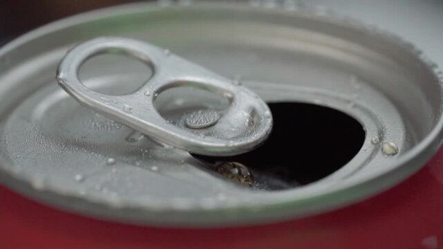 Extreme close-up of open soda can with pull tab and condensation drops