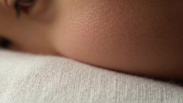 Extreme close-up view of human skin and soft fabric texture, showing delicate details.