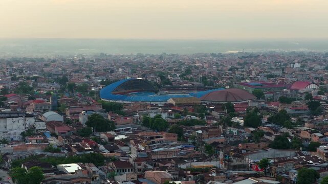 Panoramic aerial view of the city of Iquitos, located in the peruvian Amazon jungle. Hazy urban skyline at sunset with Max Augustin stadium