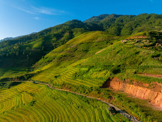 Fototapeta premium Aerial view of golden rice terraces at Mu Cang Chai town near Sapa city, North of Vietnam. Beautiful terraced rice field in harvest season in Yen Bai province.