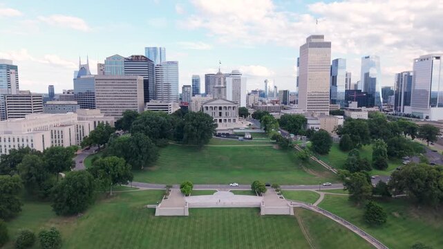 Downtown Nashville, Tennessee city skyline with a view of the state capitol building, Snow Sled Hill, and Victory Park - ascending aerial reveal