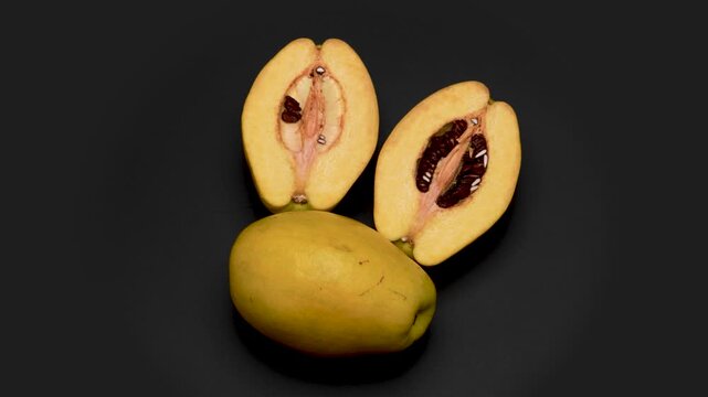半分の果林(カリン)と１つの果林を黒背景で回転させた4K動画