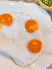 Three fried duck eggs on a plate.