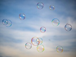 Soap Bubbles Drifting Through Air with Soft Cloud Background