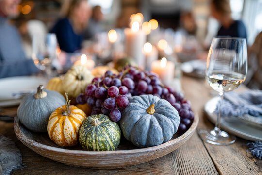 Thanksgiving dinner: diverse gourds and grapes centerpiece on rustic table