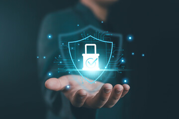 Businessman hand holding digital shield with padlock check mark icon, representing cybersecurity, data protection, online privacy, network safety, secure technology for digital business concepts.