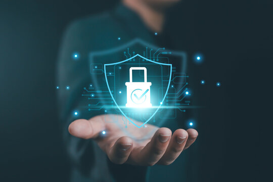 Businessman hand holding digital shield with padlock check mark icon, representing cybersecurity, data protection, online privacy, network safety, secure technology for digital business concepts.