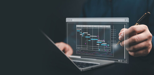 Businessman analyzing digital Gantt chart on laptop, representing project management, planning, scheduling, data analysis, productivity, and business strategy with modern technology and workflow