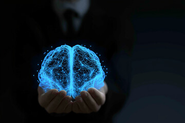A glowing blue brain hologram held in hands, symbolizing knowledge, technology, and innovation against a dark background.