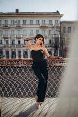 Fashionable woman in black posing with hand behind head