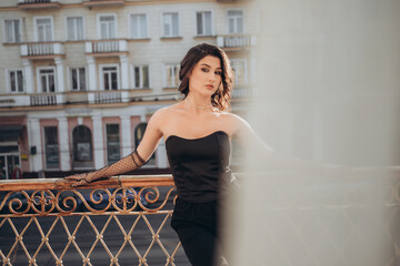 Minimalist portrait of woman in black against wall and city