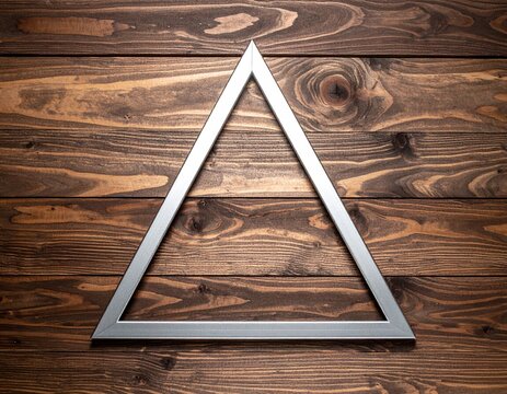 A metallic equilateral triangle lies on a wooden surface