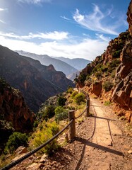 Sunny landscape photograph of a mountain path with an expansive vista