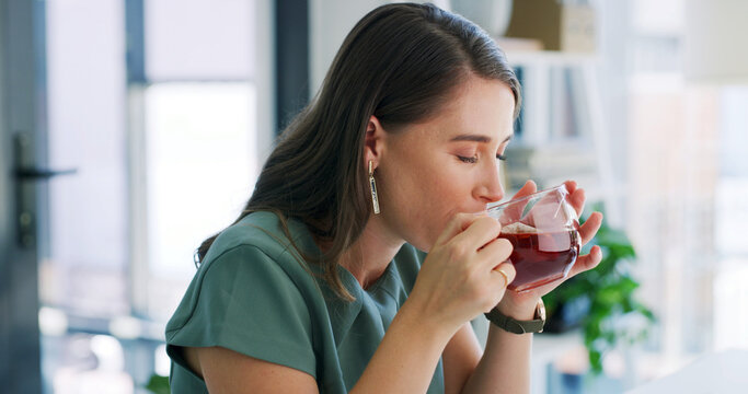 Business woman, drinking and tea with glass in office for herbal beverage, remedy or cure. Female person, employee or antioxidant with chamomile for hydration, digestion or health and wellness