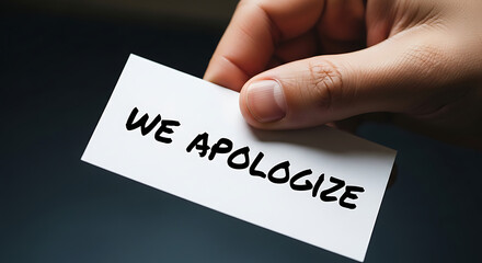 Expressing sincere regret with a 'We Apologize' message on a card, held by hand, seeking reconciliation