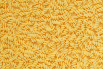 Pasta twisted into spirals on a wooden surface.