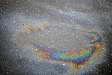 Multi colored oil spill on asphalt road, background
