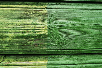 Planches de bois peintes en vert délavées. Détail de façade de maison en bois.