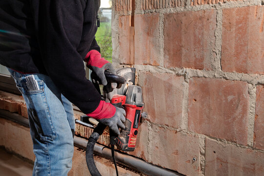 Construction Worker using a Wall Chaser to make Channels for Electric Installation