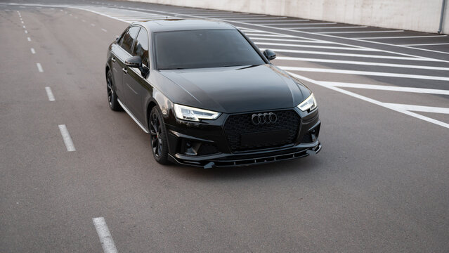 Black Audi A4 on urban road. Front view of compact executive sedan near driving towards camera. Ukraine - November 03 2024