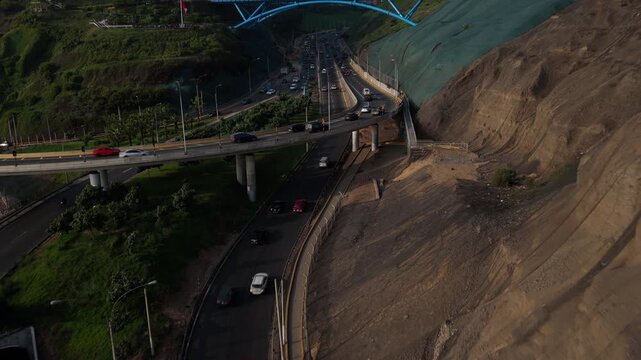 Aerial drone view of Costa Verde highway traffic in Lima, Peru showing cliffside, cityscape and Puente de la Paz between Miraflores and Barranco districts