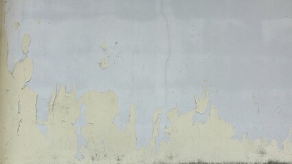 Old concrete wall painted yellow, peeling paint, scratches, dilapidated wall, wall has a cracked...