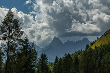 ambiente naturale di alta montagna, tra catene alpine del nord Italia, di giorno, con cielo nuvoloso, in autunno