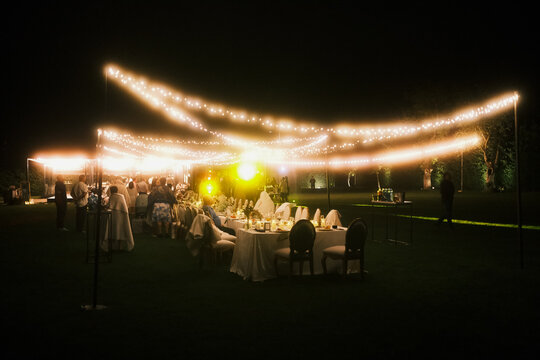 evening wine festival with merriment, evening vineyard party illuminated by lights and cheerful