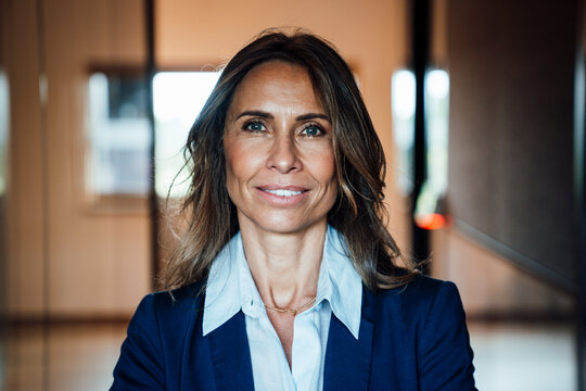 Confident businesswoman in modern office smiling at camera