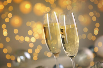 Sparkling wine in glasses, bokeh lights. New Year greeting card