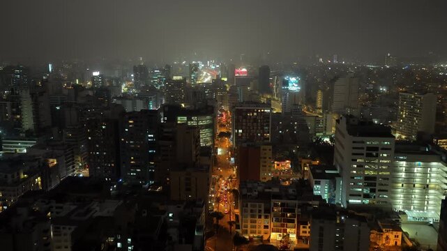 Panoramic aerial view of the city of Lima, Peru at night. Brightly lit streets and buildings of Miraflores district create vibrant urban scene