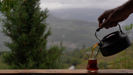 A Moment of Calm: Pouring Hot Tea in the Mountains